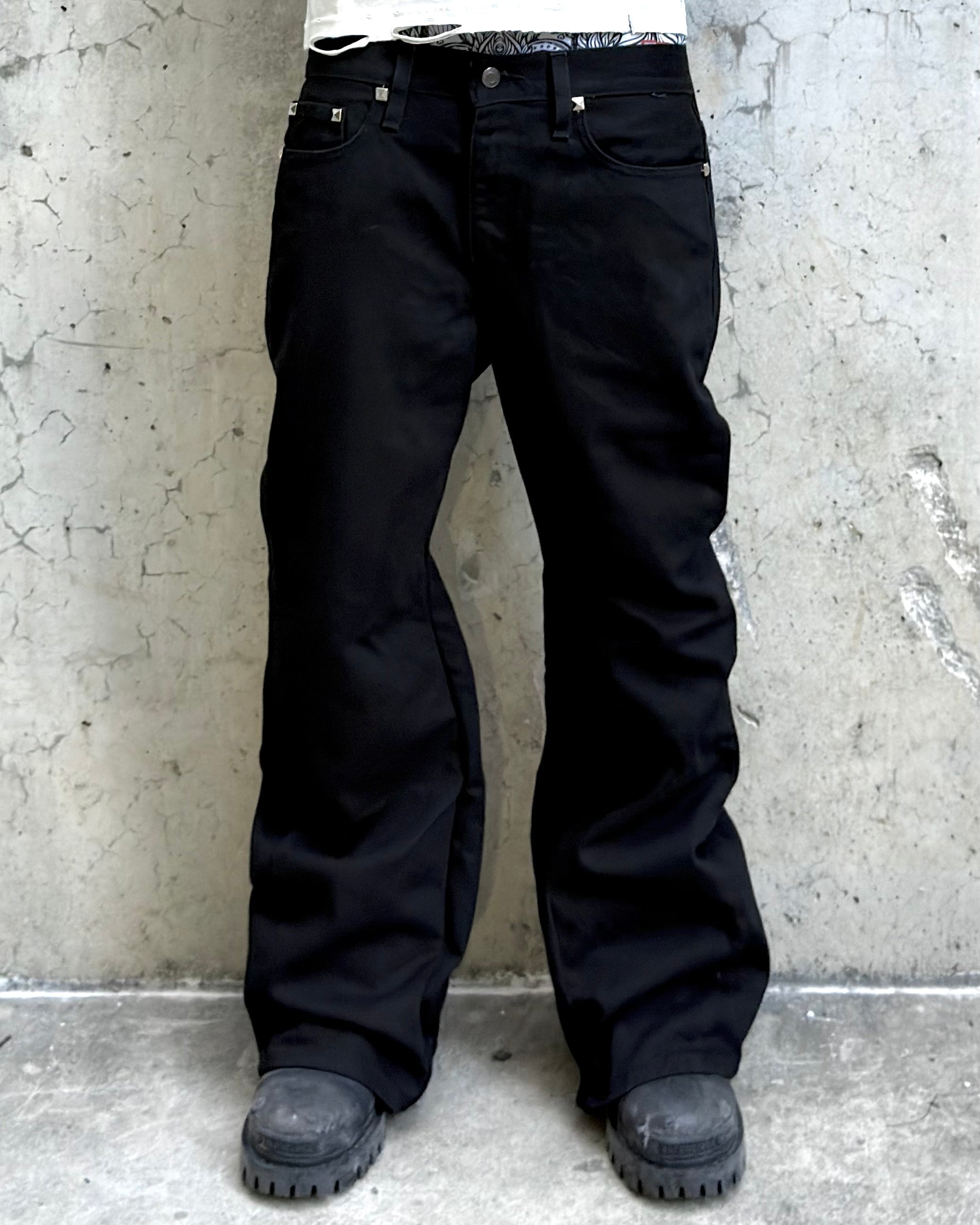 WithoutSaint studded flared denim jeans with distressed details and silver studs, showcasing a trendy, casual fit and fashionable design.