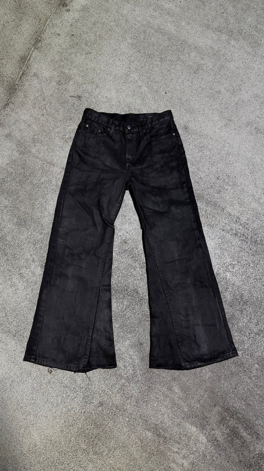 Waxed flared denim jeans by WithoutSaint, showing the fitted waist, flared legs, and textured waxed fabric detail.