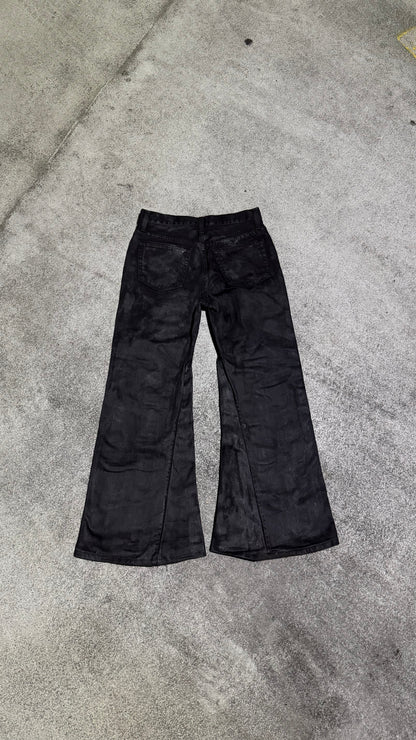 Waxed flared denim jeans by WithoutSaint, showcasing a high-waisted fit and flared leg design with a glossy, waxed finish.